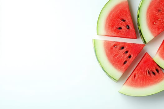 Vibrant triangular slices of watermelon rest on a pristine white background, showcasing their juicy red flesh and green rind. This refreshing fruit is perfect for hot summer days.