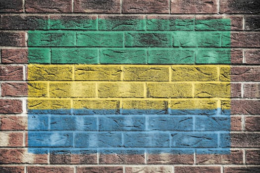 A Gabon flag painted on brick wall background