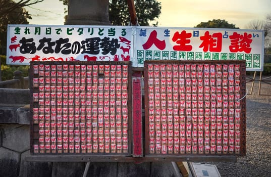 tokyo, musashikoyama - febr 23 2024: Shelf of Japanese Buddhist votive strips sold as birthday horoscopes and life advice based on zodiac signs promising fortune predictions in Ikegami Honmonji Temple