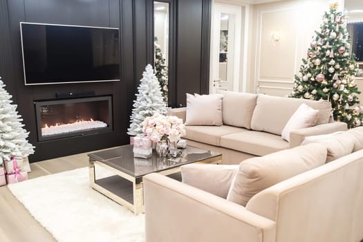 The warm living room features a stylish fireplace, a festive Christmas tree, and elegant furniture, creating a cozy holiday atmosphere.