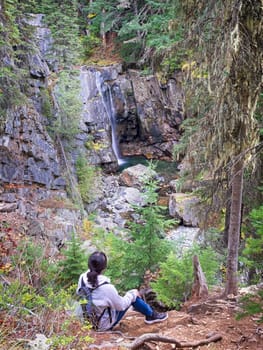 A woman hiker enjoys the stunning view of Char Falls in north Idaho.