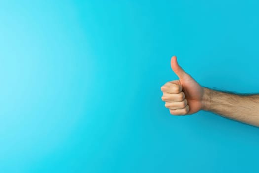 A hand is raised with a thumbs up gesture against a vibrant blue background, conveying a sense of positivity and approval. This act signifies agreement and encouragement.