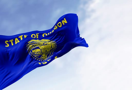Oregon state flag waving in the wind on a clear day. The Oregon flag is two-sided with navy blue and gold colors. 3d illustration render. Fluttering fabric. Waving flag