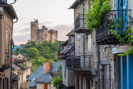 Main street in Najac village with views of the emerging medieval castle, Aveyron, France