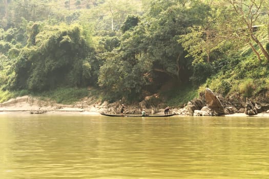 View from the slow boat from Thailand to Laos onto a fishing boat with fishermen, Laos 2023