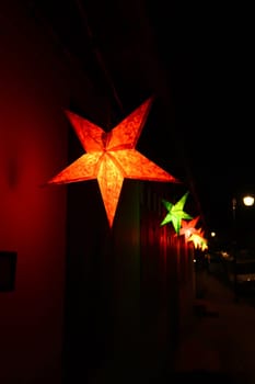 A row of colorful star shaped lanterns illuminating the night in the old town of Luang Prabang, Laos 2023