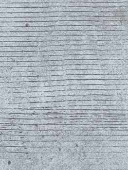 A grey and white wall with a few spots of color. The wall is made of concrete and has a rough texture