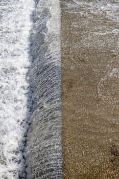 water falling from cascade edge of concrete water spillway channel slope slowing down the flow of water running down.