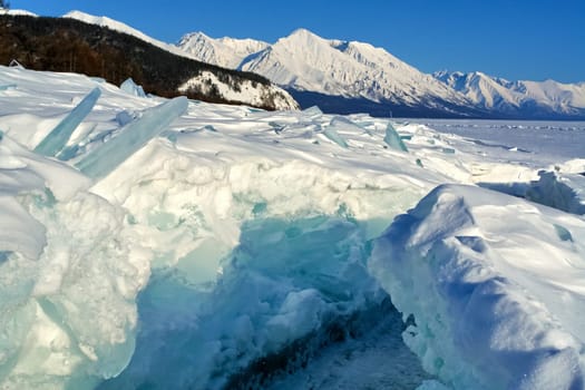 The winter landscape of Lake Baikal. Beautiful mountains in the snow and sky