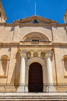 Exterior view of St. John's Co-Cathedral showcasing Baroque architectural style with carved stone details in Valletta. Cultural heritage of Malta