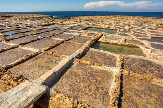 Picturesque scene of Zabbar Bay's traditional salt pans on the beach of island Malta.