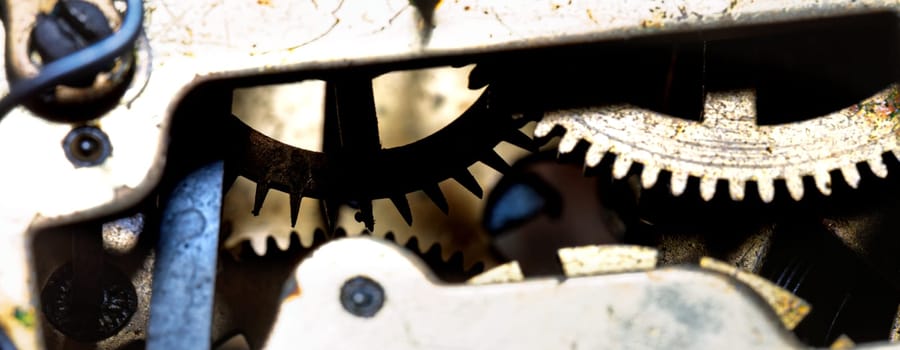 Antique watch gears with wear and oxidation showcase intricate engineering. This close-up reveals the elaborate mechanism, illustrating the detailed craftsmanship involved in early timepieces