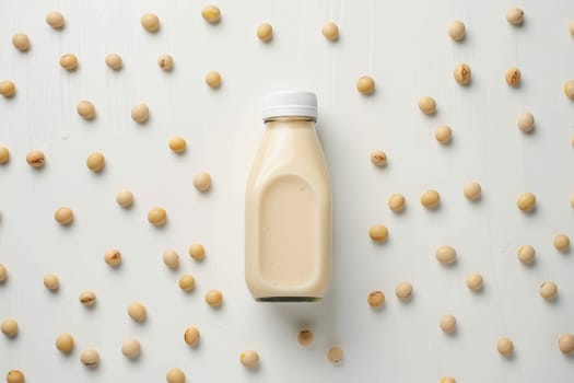 A bottle of milk is on a white background with many small white beans scattered around it