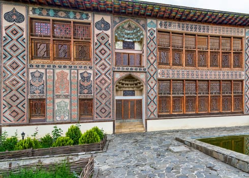 Intricate architecture of Shaki Khan's Palace, in Shaki, Azerbaijan, surrounded by lush greenery