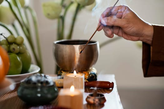 side view man lighting incense stick. High resolution photo