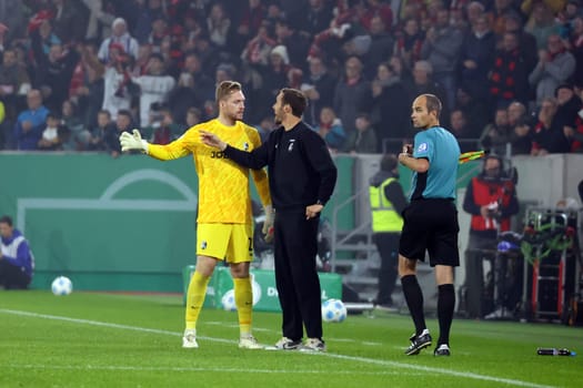 During a break in play,head coach Julian Schuster (SC Freiburg) gives instructions to goalkeeper Florian Müller (SC Freiburg) during the 2024-25 DFB-Pokal match,2nd round: SC Freiburg vs Hamburger SV
