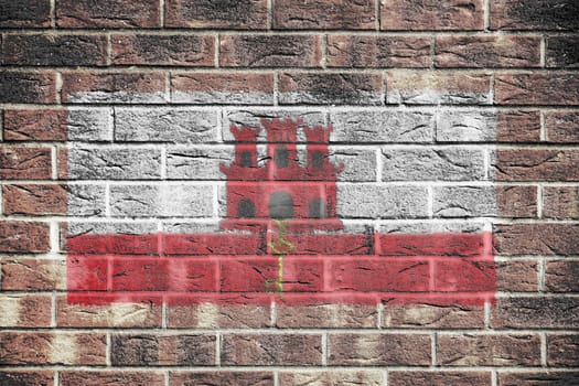 A Gibraltar flag on brick wall background