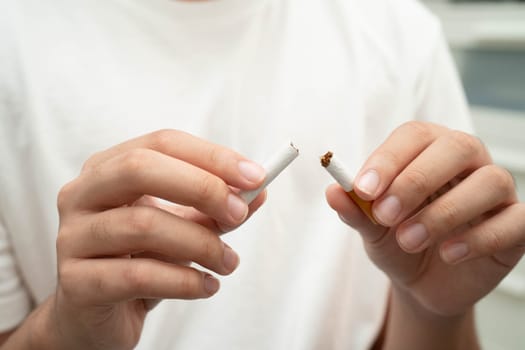 Quit smoking, Asian teenage man breaking destroy cigarette in hand.