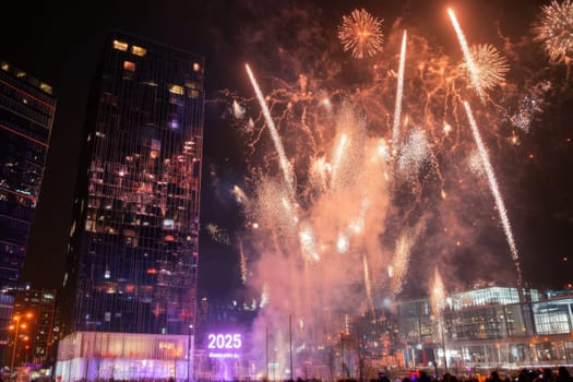 A vibrant fireworks display lights up the night sky above modern skyscrapers marking the joyful New Year celebration of 2025.