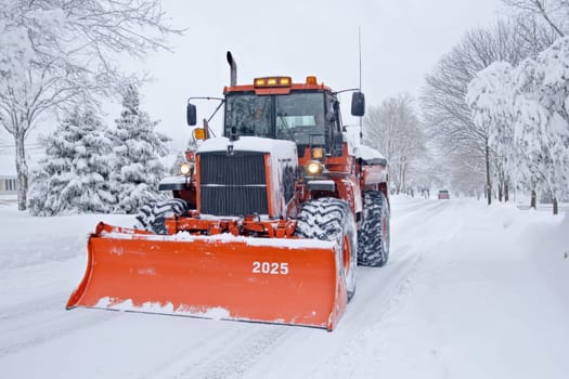 A powerful snowplow operates on a snow covered road during winter removing deep snow and ensuring safe passage for vehicles.