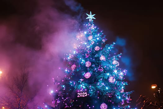 A vibrant Christmas tree is illuminated with colorful lights in a festive display creating a joyful holiday atmosphere at night.