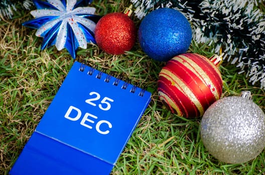 Top view of 25 December text on blue notepad with Christmas decoration background. Christmas Season and Happy Holiday concept.