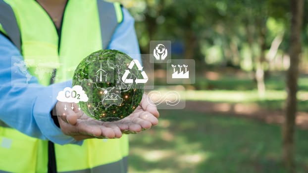 Woman engineer wearing a safety helmet on his head check the weather conditions of nature and environment. Ready to use technology to work with digital at renewable. Woman engineer show ESG icon