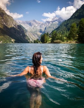 pretty young swimming woman in mountain lake, AI generated image