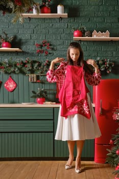 Woman puts on an apron getting ready to cook a holiday dinner in the kitchen