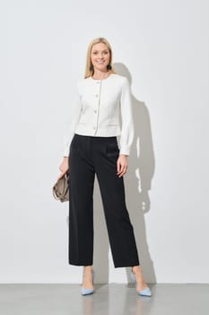 Full length portrait of stylish businesswoman in wide trousers and short blazer