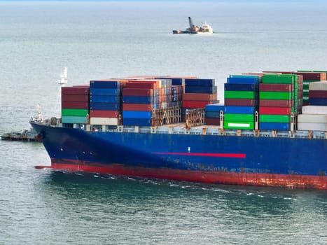 Aerial view of container cargo ship at sea. International shipping and logistics. Maritime freight transportation. Global trade and export import industry. Commercial vessel carrying containers.