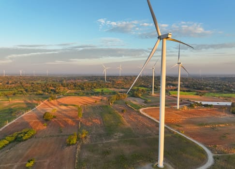 Wind farm field and sunset sky. Wind power. Sustainable, renewable energy. Wind turbines generate electricity. Sustainable development. Green technology for energy sustainability. Eco-friendly energy.