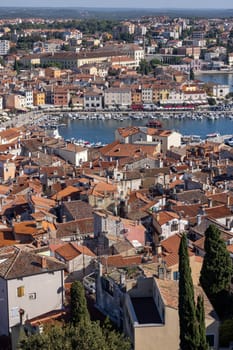 Rovinj  Croatia  Istria - September 29  2023: Aerial view from bell tower of Saint Euphemia Church of port with moored boats. Typical red ceramic roof tile