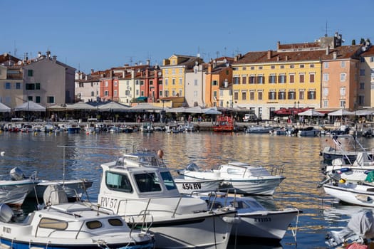 Rovinj, Croatia, Istria - September 29, 2023: Colorful tenement houses on the boulevard by the South port Rovinj over Adriatic Sea, moored boats