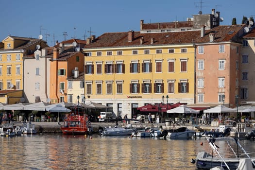 Rovinj, Croatia, Istria - September 29, 2023: Colorful tenement houses on the boulevard by the South port Rovinj over Adriatic Sea, moored boats