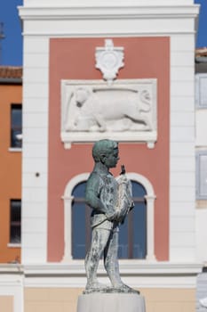 Rovinj, Croatia - September 29, 2023: Boy with Fish fountain on Marshal Tito Square in front of Tower with city clock