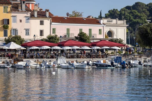 Rovinj, Croatia, Istria - September 29, 2023: Colorful tenement houses on the boulevard by the South port Rovinj over Adriatic Sea, moored boats