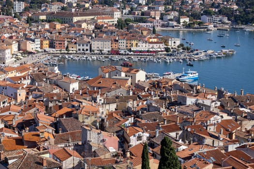 Rovinj  Croatia  Istria - September 29  2023: Aerial view from bell tower of Saint Euphemia Church of port with moored boats. Typical red ceramic roof tile