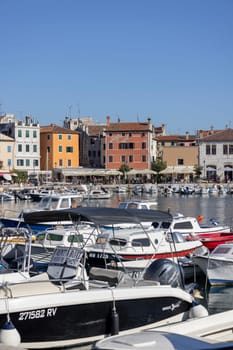Rovinj, Croatia, Istria - September 29, 2023: Colorful tenement houses on the boulevard by the South port Rovinj over Adriatic Sea, moored boats
