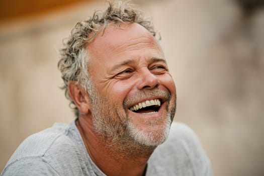 Middle-aged man laughing heartily, capturing a moment of pure joy and happiness.