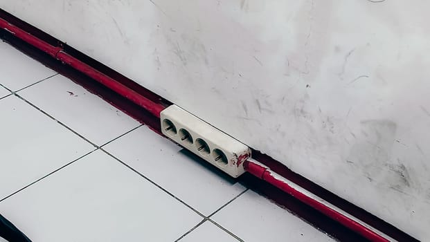 A red and white striped object is on the floor. The red stripe is on the bottom of the object