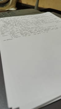 Close-up of a stack of printed papers resting on an office printer tray, highlighting everyday office tasks and technology. Suitable for illustrations about printing, office work, and document management.