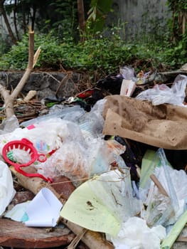 Image showcasing discarded waste, including plastics and paper, in a natural setting. Highlights the environmental impact and challenges of pollution. Emphasizes the need for proper waste management.