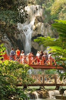 Many people are gathering on the bridge in front of the Kuang Si Waterfall, Fall, close to Luang Prabang, Laos 2023