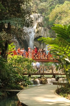 Many people are gathering on the bridge in front of the Kuang Si Fall, Waterfall, close to Luang Prabang, Laos 2023