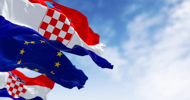 Flags of Croatia and the European Union fluttering together on a clear day. 3D illustration render. Fluttering fabric. Selective focus