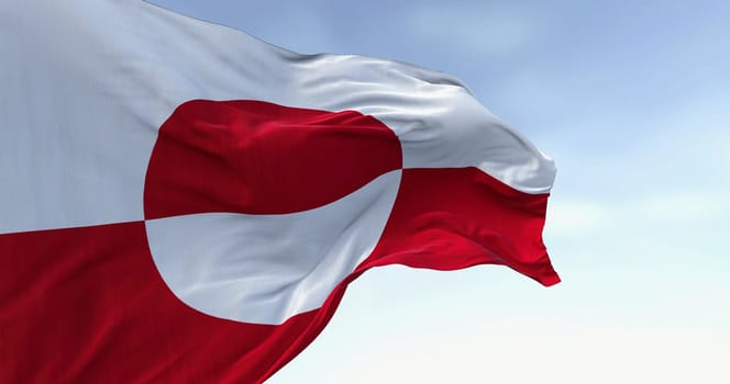 The flag of Greenland waving in the wind on a clear day. Greenland is the world's largest island, and one of the three constituent countries that form the Kingdom of Denmark