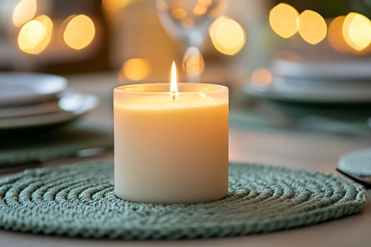 A softly glowing candle rests on a textured green placemat, surrounded by blurred fairy lights and dining essentials, creating a cozy atmosphere.