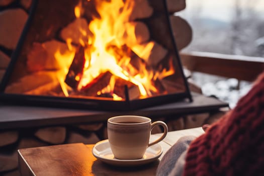 Sipping a hot beverage while relaxing by a glowing fireplace, surrounded by warm wooden decor on a chilly winter day.