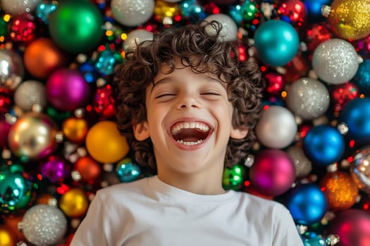 A joyful child with curly hair lays among vibrant Christmas ornaments, laughing happily during the festive season.